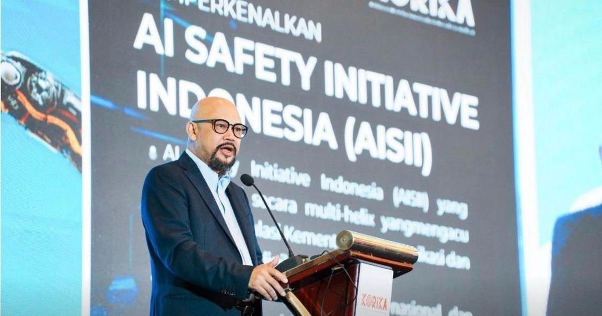 Pembicara di podium acara KORIKA dengan layar bertuliskan AI Safety Initiative Indonesia